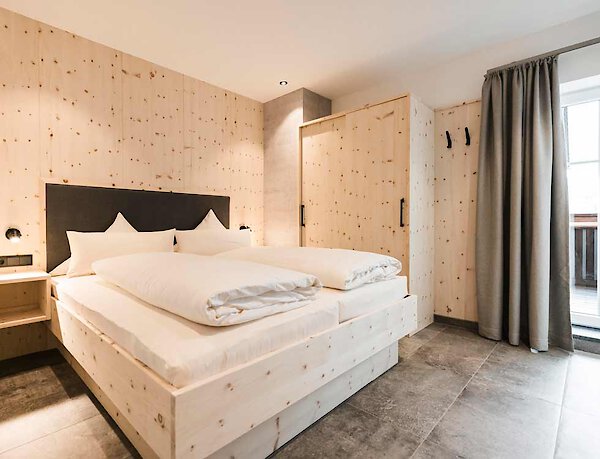 Komfortables Schlafzimmer mit großem Doppelbett aus Holz